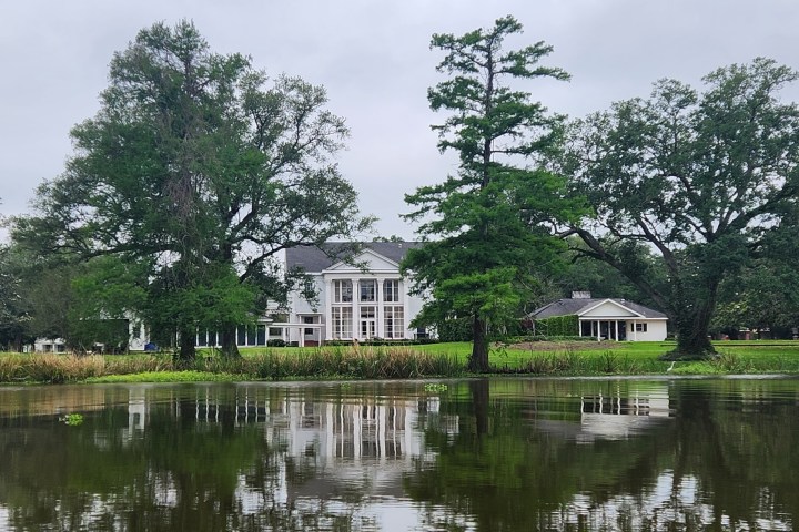 a small house in a body of water surrounded by trees